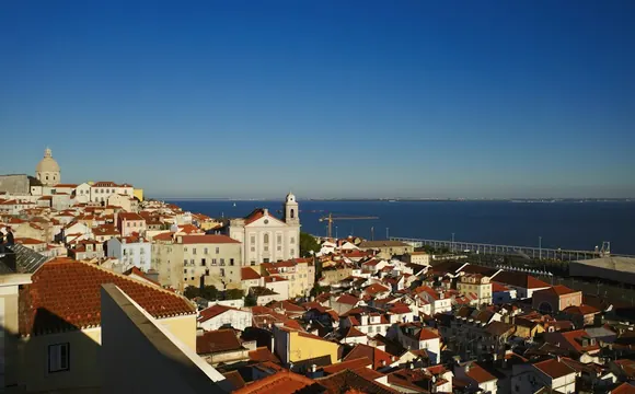 Historic rooftops and the Tagus River in Lisbon, Portugal.