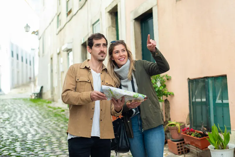 Local tour guide leading travelers through the colorful streets of Lisbon, Portugal, sharing stories and hidden gems.