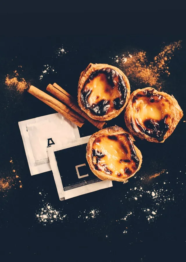 Pastel de nata on a wooden table at Aloma bakery with coffee.