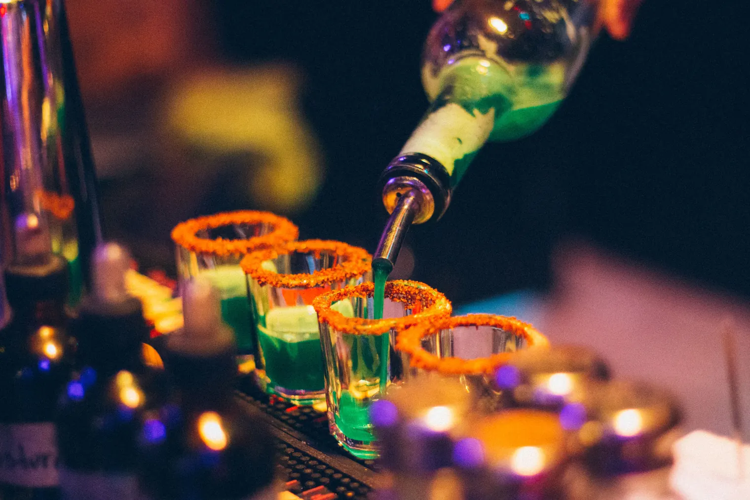 Bartender pouring Polish vodka into shot glasses with salted rims in a Warsaw bar