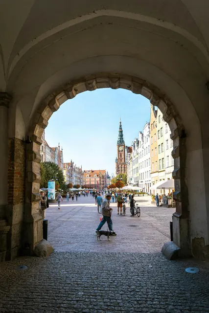 Gdańsk Old Town featuring Neptune's Fountain and colorful merchant houses along Długi Targ street with St. Mary's Basilica in the background