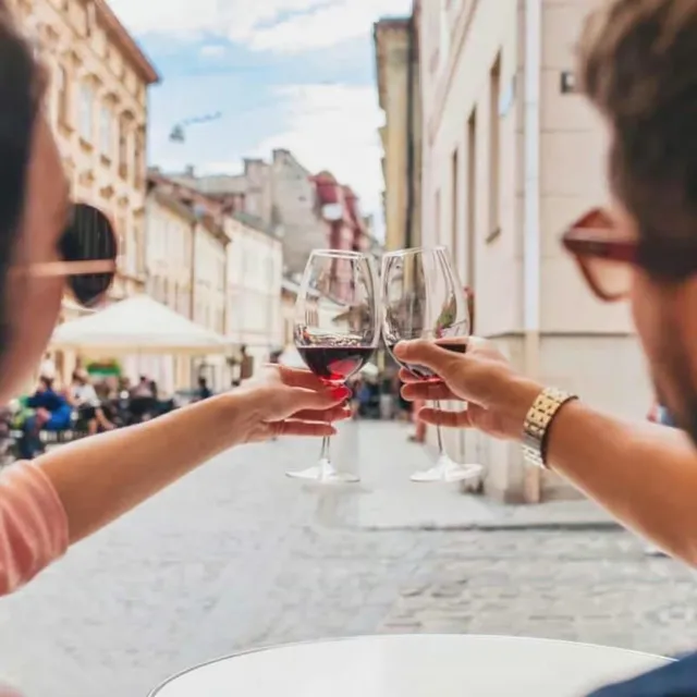 Glasses raised beside colourful Porto buildings.