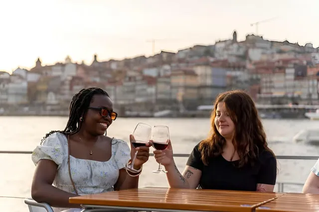 Guests raising glasses with Porto rooftops behind them.