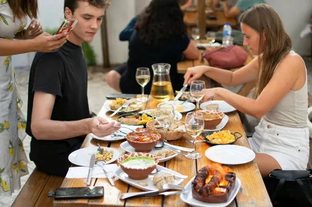 Guests sharing food around a table in Lisbon.