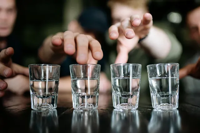 A hand placing a tasting glass on a table.