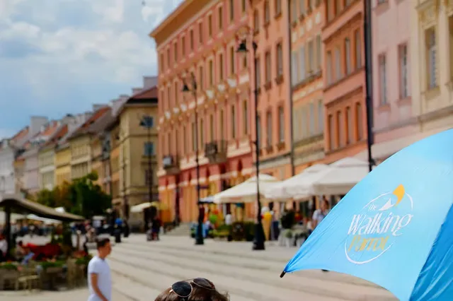 A guide with a blue The Walking Parrot umbrella.