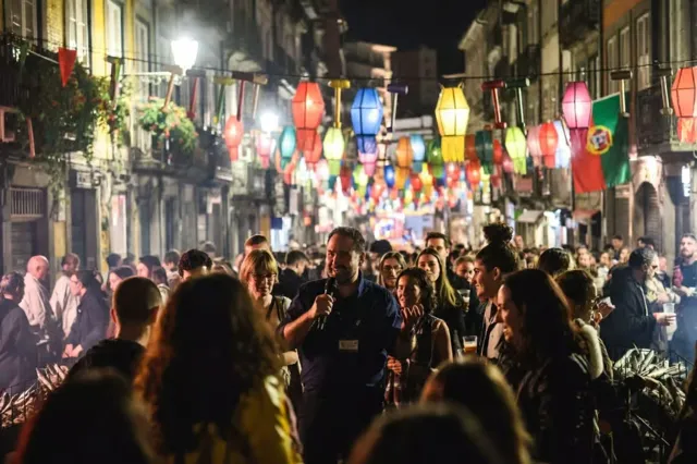 A crowd beneath street decorations at night.